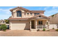 Charming two-story home featuring a red tile roof, a two-car garage, and a cozy front porch at 10276 Cherry Brook St, Las Vegas, NV 89183