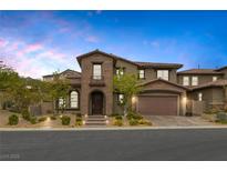 Charming two-story home featuring brick and stucco, manicured landscaping, and a two-car garage at 11944 Dolcemente Ln, Las Vegas, NV 89138