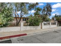 Charming front yard featuring mature trees and colorful bushes at 1674 Palma Vista Ave, Las Vegas, NV 89169