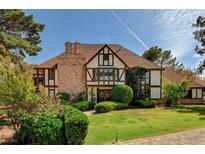 Charming Tudor-style home with brick and stucco exterior, lush landscaping, and a well-maintained lawn at 3141 E Katie Ave, Las Vegas, NV 89121