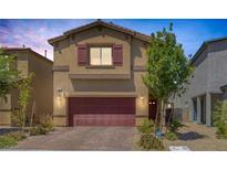 Inviting two-story home featuring a red garage door, landscaped yard, and a welcoming entrance at 3808 Seyfert Ave, North Las Vegas, NV 89084