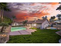 Expansive backyard featuring a pristine pool, lush lawn, and a serene setting ideal for relaxation at 5840 N El Capitan Way, Las Vegas, NV 89149