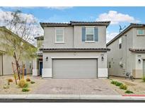 Charming two-story home featuring a two-car garage, neutral tones, and a beautifully landscaped front yard at 6130 Yuzu Pl, Las Vegas, NV 89122