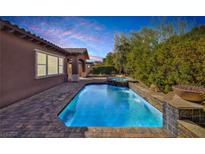 Sparkling pool and spa with mature landscaping and a beautiful sunset view at 775 Porto Mio Way, Las Vegas, NV 89138