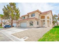 Charming stucco home featuring a red tile roof, arched entryway, and a spacious two-car garage at 8753 Fountain Island Dr, Las Vegas, NV 89147