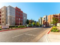 A low-angle full shot of the apartment community, manicured grounds, and resident entrance on a beautiful, sunny day at 20 E Serene Ave # 111, Las Vegas, NV 89123