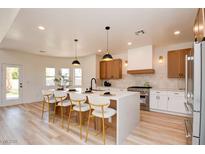 Modern kitchen with white countertops, wooden cabinets, island seating, and stainless steel appliances at 8080 Black Orchid Ave, Las Vegas, NV 89131