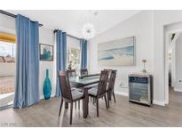 Bright dining room features a modern chandelier and glass-top table with seating for six at 9445 Grand Mesa Dr, Las Vegas, NV 89134