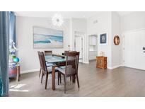 Bright dining room featuring a glass-top table, modern light fixture, and beach-themed art at 9445 Grand Mesa Dr, Las Vegas, NV 89134