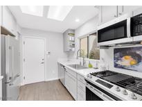 Bright kitchen with white cabinets, quartz countertops, stainless appliances and a window view at 9445 Grand Mesa Dr, Las Vegas, NV 89134