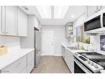 Bright kitchen features white cabinets, quartz countertops, and stainless steel appliances at 9445 Grand Mesa Dr, Las Vegas, NV 89134