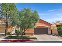 Charming home with a two-car garage, tree in the front, and a well-manicured lawn in a lovely community at 12 Via Ravello, Henderson, NV 89011