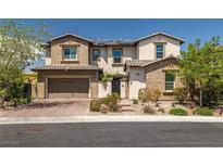 Charming two-story home with brick accents, a two-car garage, and beautifully landscaped front yard at 12024 Girasole Ave, Las Vegas, NV 89138