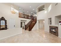 Elegant foyer features a grand staircase, soaring ceilings, fireplace, and marble floors at 1265 Vietti St, Henderson, NV 89012
