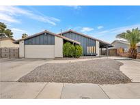 Inviting home exterior featuring desert landscaping, a two-car garage, and a charming facade at 5120 Burnham Ave, Las Vegas, NV 89119