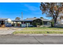 Charming single-story home featuring a well-maintained lawn, covered carport, and mature landscaping at 709 New Mexico St, Boulder City, NV 89005