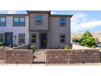 Charming two-story townhouse with neutral exterior and a quaint front yard featuring a low brick wall at 756 Sleeping City Ave, Henderson, NV 89015