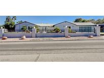 Charming single-story home featuring a decorative metal gate and desert landscaping for curb appeal at 7575 Coley Ave, Las Vegas, NV 89117