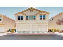 Traditional townhome featuring an attached garage, neutral stucco exterior, and well-maintained landscaping at 8811 Tomnitz Ave # 101, Las Vegas, NV 89178