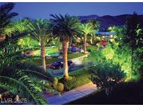 Extensive driveway with palm trees and landscaping leads to the home in this nighttime shot at , Henderson, NV 89012