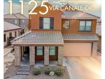 Two-story home featuring a tile roof, a covered front porch with stone pillars, and a two car garage at 1125 Via Canale Dr, Henderson, NV 89011
