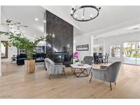 Bright living room featuring hardwood floors, fireplace, and modern gray furniture set at 2337 Prometheus Ct, Henderson, NV 89074