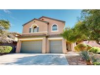 Inviting two-story home boasts a three-car garage, desert landscaping, and a charming terracotta roof at 3425 Fledgling Dr, North Las Vegas, NV 89084