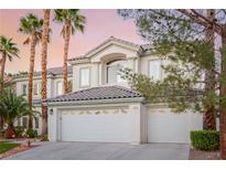 Elegant two-story home boasting a three-car garage, palm trees, and well-maintained landscaping at 44 Tamarron Cliffs St, Las Vegas, NV 89148