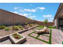 Backyard featuring brick patio, mature landscaping, and a beautiful stone fountain at 715 Drammatico Pl, Henderson, NV 89011