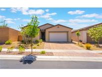 Charming single-story home featuring a well-manicured front yard and brick paver driveway at 715 Drammatico Pl, Henderson, NV 89011