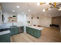 Bright, renovated kitchen boasts green cabinets, marble countertops, and stainless steel appliances at 7932 Diamond Rock Way # 101, Las Vegas, NV 89128