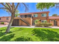 Well-maintained two-story townhouse with manicured landscaping, staircase, and charming red tile roof at 250 Shadybrook Ln # D, Las Vegas, NV 89107