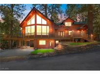 Stunning log home featuring a large deck, ample windows, and beautiful landscaping at 274 Ski Trail Rd, Mount Charleston, NV 89124