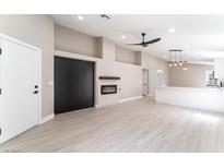Bright living room with modern fireplace, sleek ceiling fan, and durable wood-look floors at 4149 Compass Rose Way, Las Vegas, NV 89108