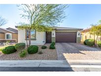 Charming single-story home showcasing a well-manicured lawn and a two-car garage, complete with stone accents and desert landscaping at 5633 Alitak Bay St, North Las Vegas, NV 89081