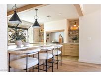 Bright kitchen features a quartz island, modern lighting fixtures, stone accents, and wood beams at 5741 S Pearl St, Las Vegas, NV 89120