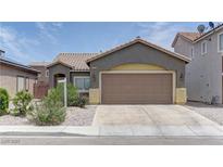 Charming single-story home featuring a two-car garage, desert landscaping, and a stucco exterior at 6236 Tierra Cove St, North Las Vegas, NV 89081