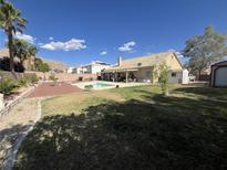 Expansive backyard with a sparkling pool, mature landscaping, and covered patio, perfect for outdoor entertaining at 6596 Secluded Ave, Las Vegas, NV 89110