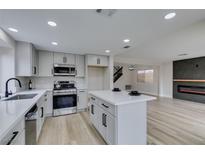 Modern kitchen featuring stainless steel appliances, an island, and sleek cabinets at 71 Sea Holly Way, Henderson, NV 89074