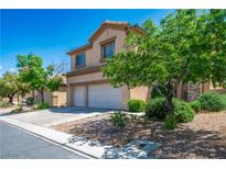 Two-story home with a two-car garage, desert landscaping, and a driveway on a sunny day at 81 Alpine Bay Ave, Las Vegas, NV 89148