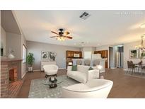 Bright, open living area with hardwood floors, fireplace, ceiling fan, and bar seating in the kitchen at 8728 Tom Noon Ave # 103, Las Vegas, NV 89178
