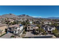 An aerial view of a suburban neighborhood showcases lovely homes against the backdrop of beautiful mountains at 12124 Kite Hill Ln, Las Vegas, NV 89138