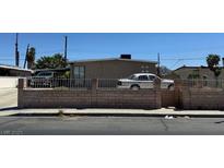 Modest single-story home with neutral paint, block wall, and minimal landscaping on a sunny day at 1908 Palmer St, North Las Vegas, NV 89030