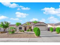 Charming single-story home featuring desert landscaping, a two-car garage, and a well-maintained lawn at 2514 Tropical Sands Ave, North Las Vegas, NV 89031
