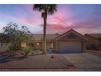 Charming single-story home with a well-manicured front yard, complemented by a mature palm tree at sunset at 3012 Haddon Dr, Las Vegas, NV 89134