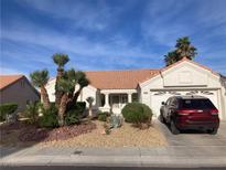 Charming single-story home featuring a well-manicured front yard with drought tolerant desert landscaping and a red SUV in the driveway at 3024 Lotus Hill Dr, Las Vegas, NV 89134