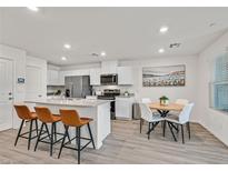 Bright eat-in kitchen features stainless appliances, white cabinetry, and three-seat island at 3762 Sonrisa Vista Ave, Henderson, NV 89044