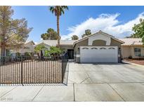 Charming single-story home featuring a well-manicured front yard, mature trees, and a two-car garage at 5045 Sock Hop Way, North Las Vegas, NV 89031