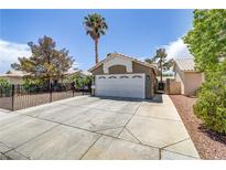 Front exterior features a two-car garage, low maintenance yard, and a desert landscape at 5045 Sock Hop Way, North Las Vegas, NV 89031