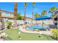 Inviting backyard featuring a sparkling pool with rock waterfall and adjacent putting green at 11732 Del Sur Ave, Las Vegas, NV 89138